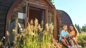 children sat outside a glamping pod at Whitemead